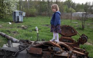 Makariv, UKRAINE, girl stands on the tower of a destroyed Russian tank